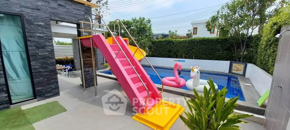 Vibrant backyard pool with colorful slide and inflatables, perfect for family fun and relaxation.