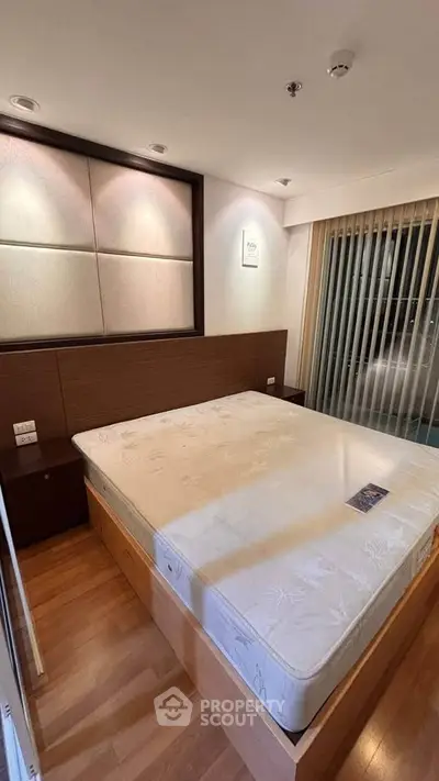 Spacious bedroom with modern design and large window for natural light.
