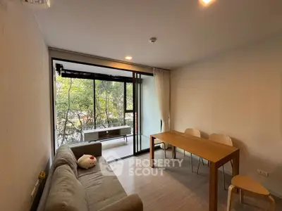 Modern living room with balcony view, featuring cozy sofa and dining table, perfect for relaxation and entertaining.