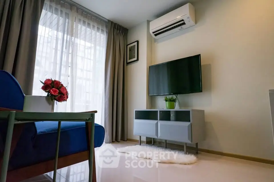Modern living room with air conditioning, TV, and stylish decor in a bright apartment.