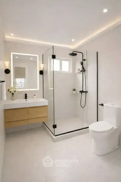 Modern bathroom with glass shower, sleek vanity, and elegant lighting