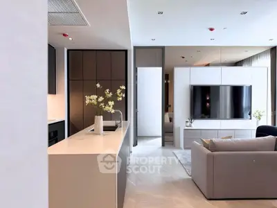Modern open-plan living room with sleek kitchen and large TV, perfect for contemporary living.
