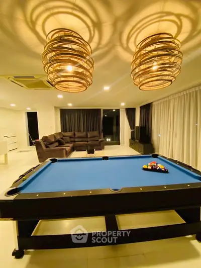 Luxurious living room with pool table and stylish lighting, perfect for entertainment and relaxation.