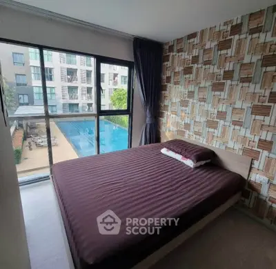 Modern bedroom with pool view in stylish apartment complex