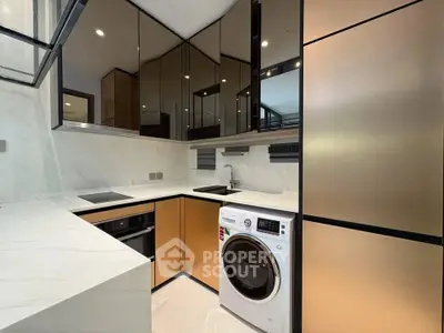 Modern kitchen with sleek cabinetry, built-in appliances, and a washing machine in a compact layout.