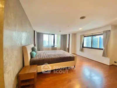Spacious bedroom with large windows and wooden flooring in modern apartment