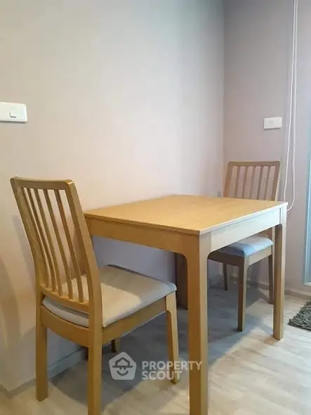 Cozy dining area with wooden table and chairs in modern apartment.