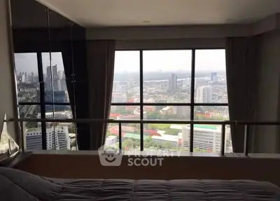 Stunning high-rise bedroom with panoramic city view and floor-to-ceiling windows.