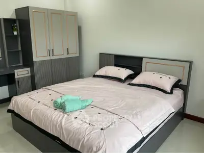 Modern bedroom with stylish grey furniture and cozy bedding, perfect for relaxation and comfort.