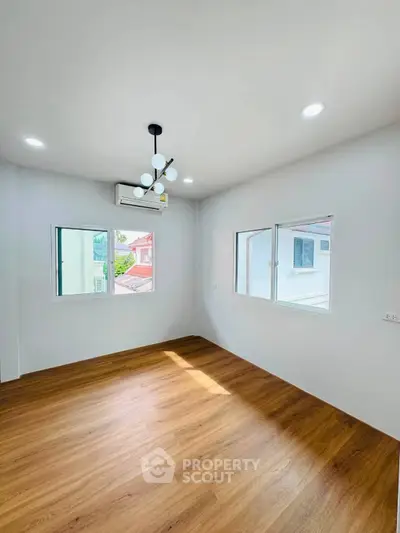 Bright and airy room with modern lighting and wooden flooring, perfect for a cozy living space.