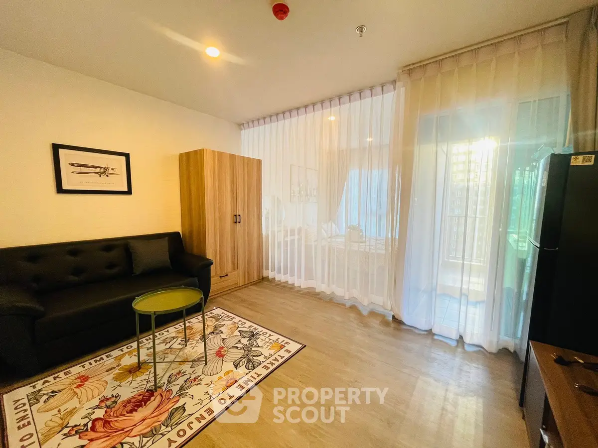 Modern living room with stylish decor, featuring a cozy sofa, elegant curtains, and a vibrant floral rug.