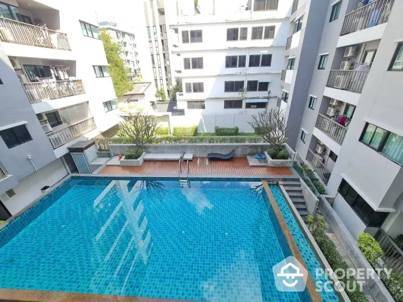 Modern apartment complex with inviting swimming pool and sun deck area.