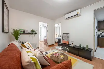 Stylish living room with modern decor and cozy ambiance, featuring air conditioning and open access to bedroom.