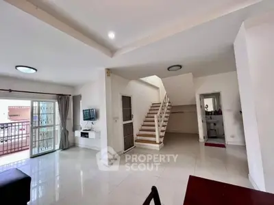 Spacious modern living room with staircase and balcony access
