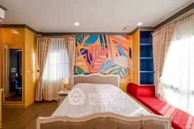 Vibrant bedroom with colorful mural and elegant furnishings, featuring a cozy bed and ample natural light.