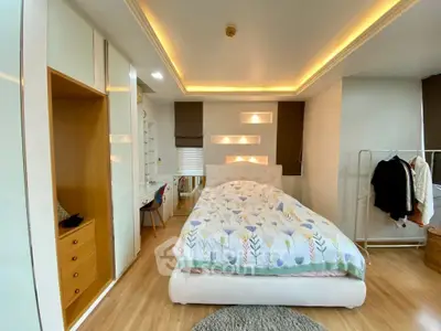 Spacious bedroom with modern lighting and cozy decor