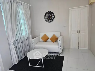 Chic living room with modern decor, featuring a stylish sofa, elegant curtains, and a contemporary wall clock.