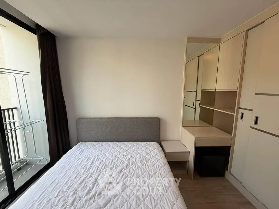 Modern bedroom with balcony access and built-in wardrobe in a stylish apartment.