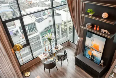 Stunning high-rise apartment with floor-to-ceiling windows and elegant dining area overlooking cityscape.