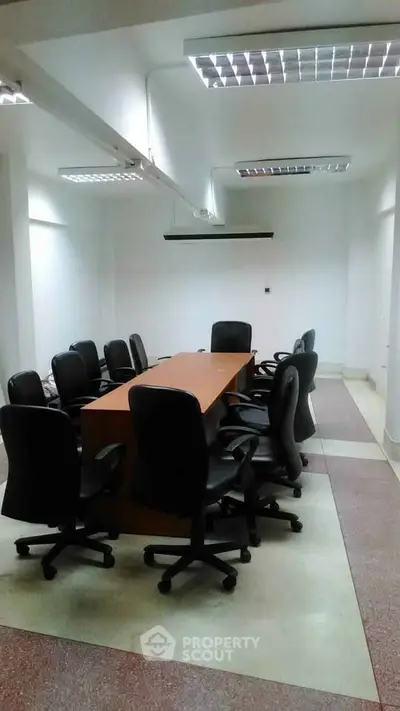 Spacious office meeting room with modern chairs and large conference table.