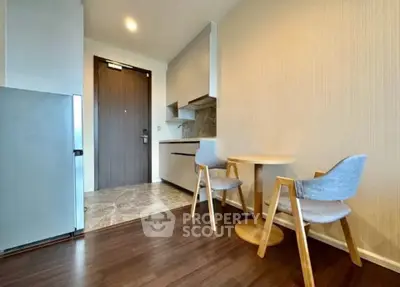 Modern kitchen with sleek design and cozy dining area in a stylish apartment.