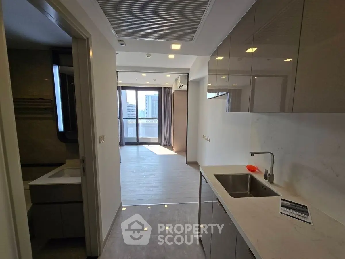 Modern apartment interior with sleek kitchen and city view balcony.