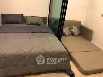 Cozy bedroom with modern bed and compact sofa in stylish apartment