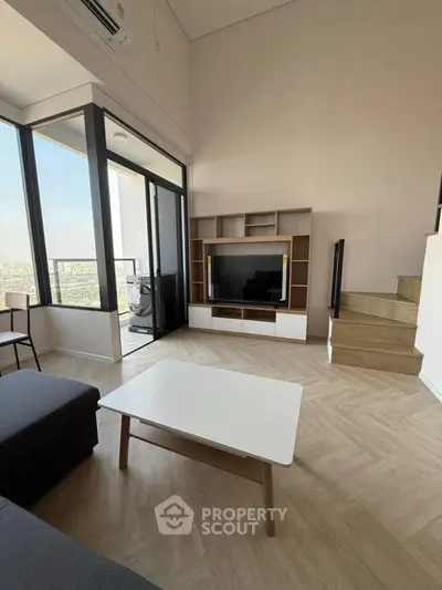 Modern living room with large windows and city view, featuring stylish furniture and wooden flooring.