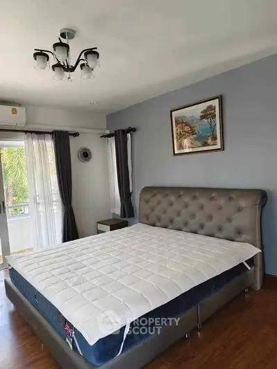 Spacious bedroom with elegant decor and large window view