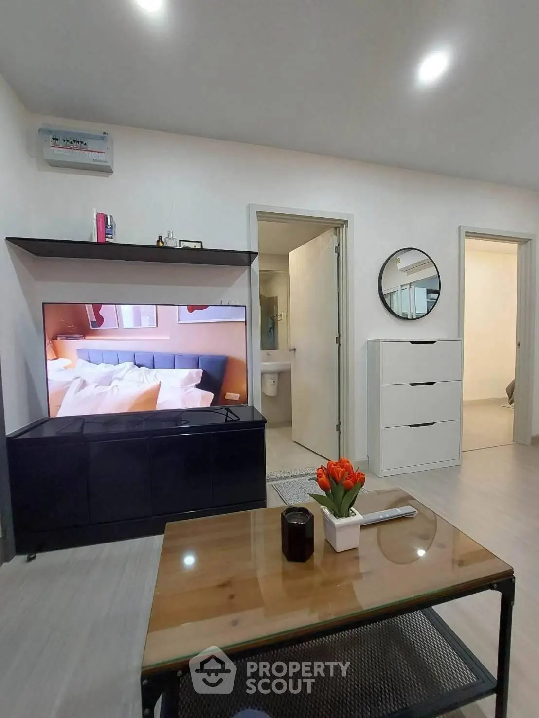 Modern living room with sleek furniture and wall-mounted TV, showcasing a stylish and cozy interior design.