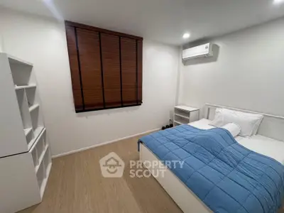 Cozy bedroom with modern furnishings and air conditioning, perfect for a comfortable living experience.