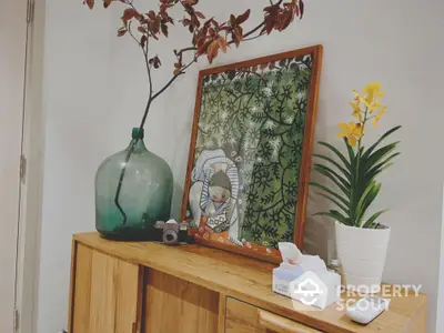 Stylish interior decor with wooden cabinet, art piece, and plants for a cozy home ambiance.