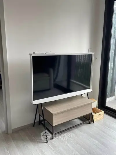 Modern living room with sleek TV stand and large window for natural light.