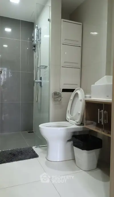 Modern bathroom with sleek design, featuring a glass shower and contemporary fixtures.