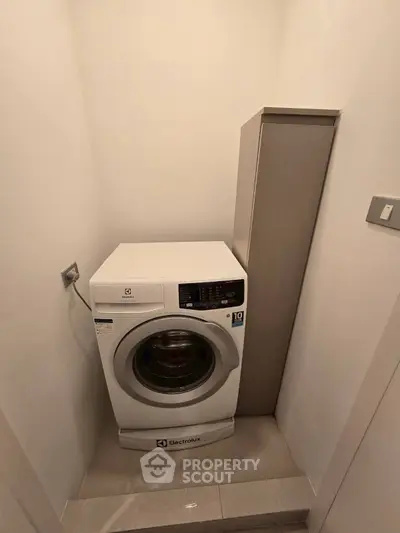 Compact laundry area with Electrolux washing machine in modern apartment.