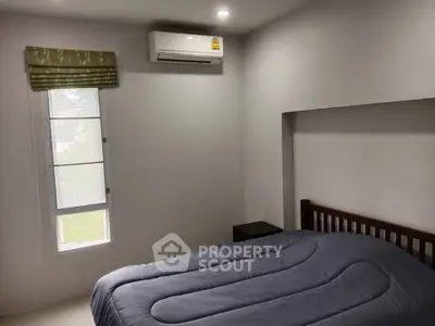 Cozy bedroom with air conditioning and natural light, perfect for relaxation.
