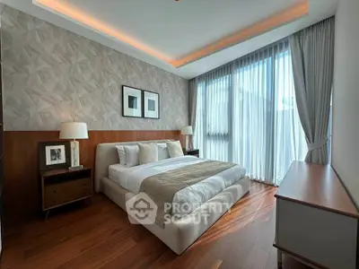 Luxurious bedroom with elegant decor, large windows, and wooden flooring, offering a serene and inviting atmosphere.