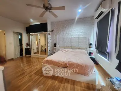 Spacious bedroom with modern decor and wooden flooring