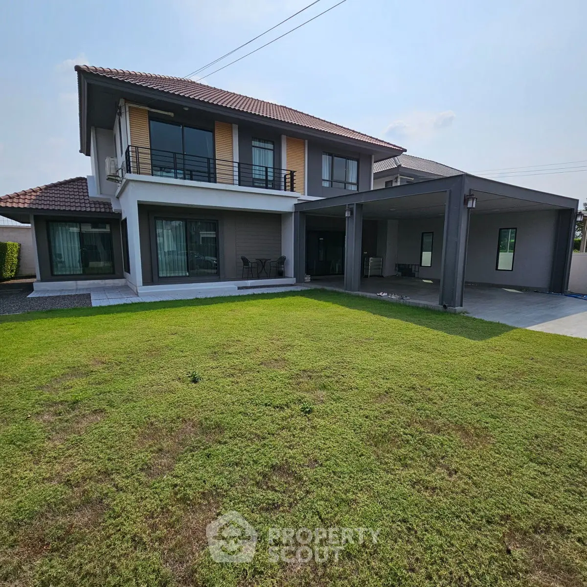 Spacious modern two-story house with large lawn and covered parking area