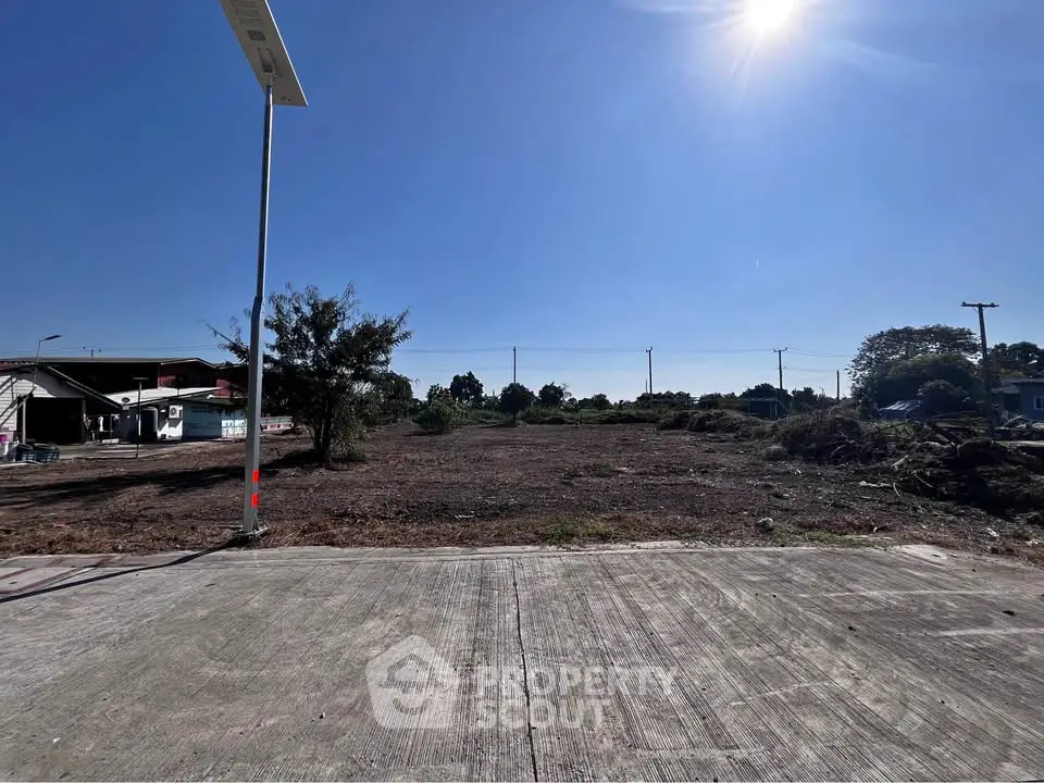 Expansive vacant land under clear blue sky, perfect for development opportunities.
