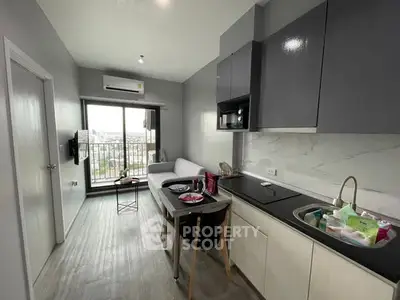 Modern apartment with open kitchen and living area, featuring sleek cabinetry and a city view.