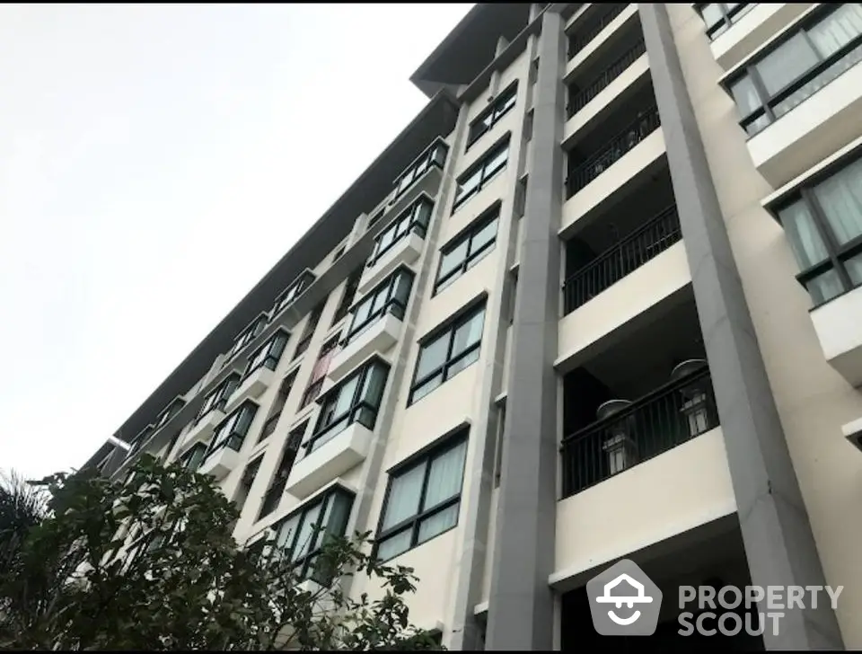 Modern multi-story apartment building with large windows and balconies