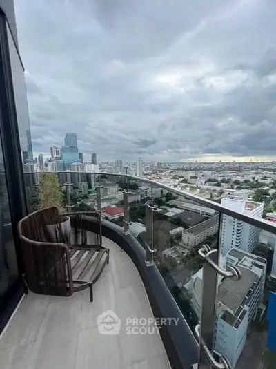 Stunning cityscape view from a modern high-rise balcony with sleek glass railing.