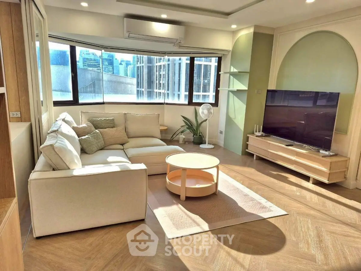Spacious modern living room with large windows and stylish furniture in a high-rise apartment.