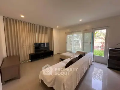 Spacious living room with modern decor and large windows offering natural light.