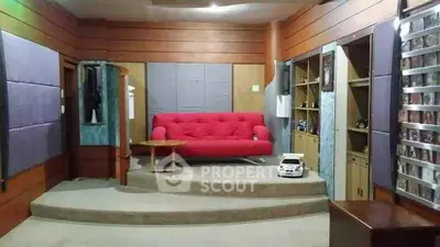 Cozy living room with red sofa and built-in wooden shelves