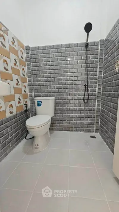 Modern bathroom with stylish gray brick tiles and sleek shower design.