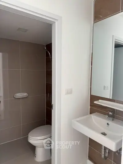 Modern bathroom with sleek design featuring a wall-mounted sink and compact toilet.