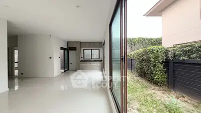 Spacious modern living area with large windows and garden view