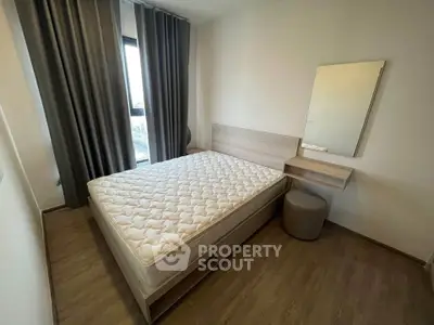 Modern bedroom with minimalist design and large window for natural light.